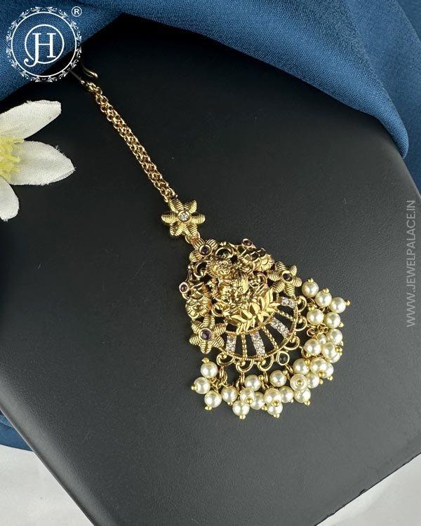 Antique Gold Premium Tikka JH6534 1 Antique gold premium tikka featuring intricate designs and detailed embellishments, perfect for adding a touch of elegance and tradition to any outfit or occasion
