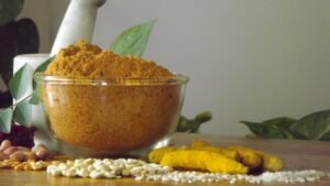 Homemade Dharwad Chutney Pudi in a glass jar with red chili and garlic